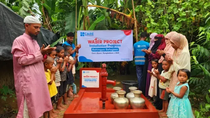 A girl fills a cup at a new CBB hand-pump in Bangladesh