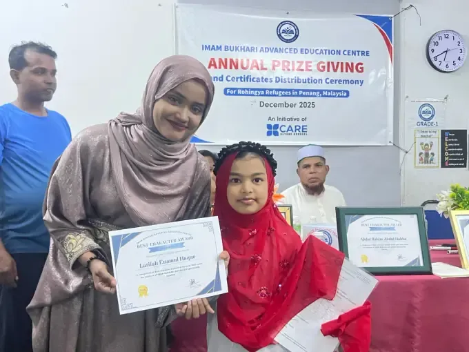 A student receives a certificate at a CBB Annual Prize Giving