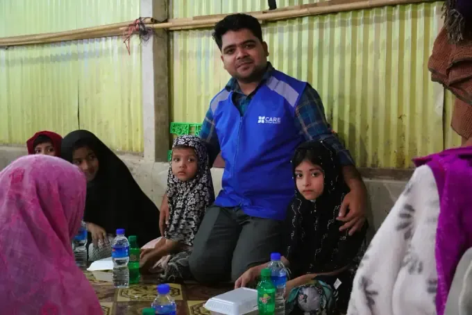 A CBB volunteer with two sponsored children and food