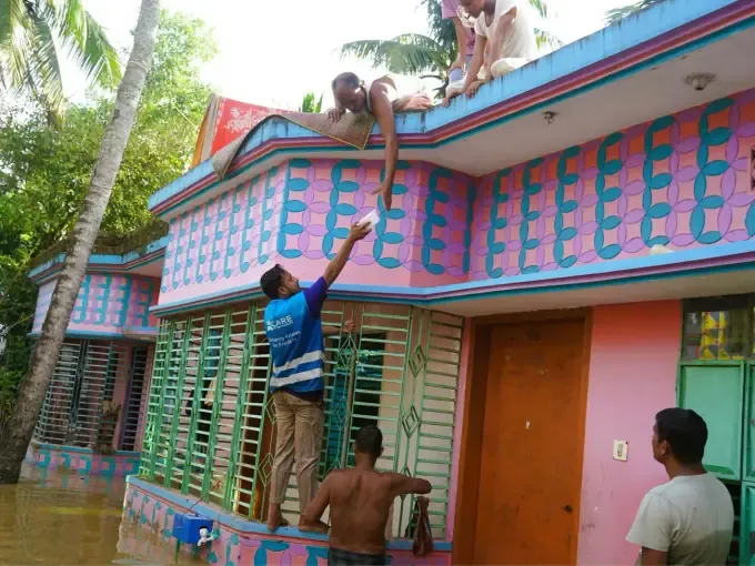 Workers repair a flood-damaged home with CBB support