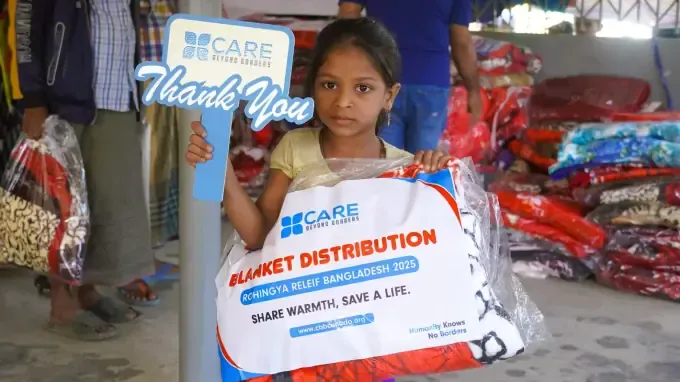 A girl with a CBB blanket pack at a Share Warmth distribution