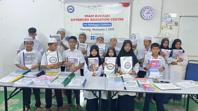 Girls hold new CBB workbooks at school