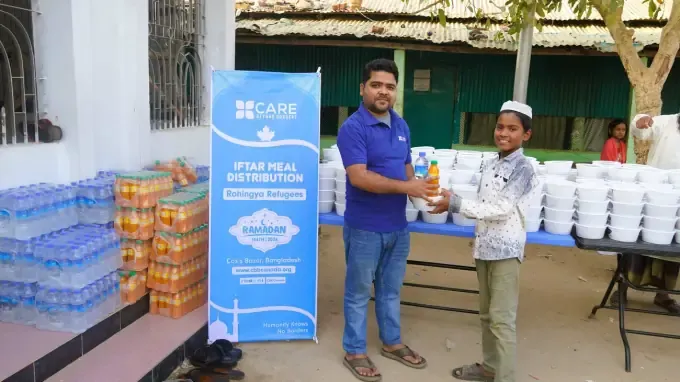 A CBB volunteer hands an iftar meal to a recipient