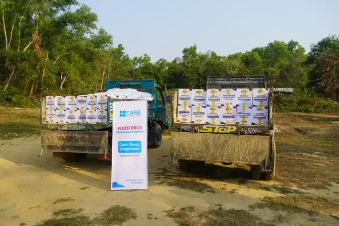 A CBB volunteer with cooking oil and staples for food packs