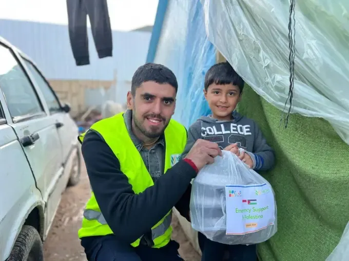 A CBB volunteer gives bottled water to a boy