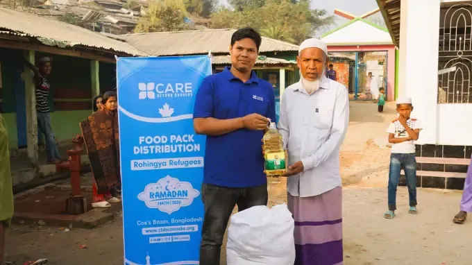 A man receives a CBB food pack with cooking oil