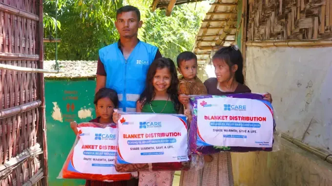 A CBB volunteer with children holding blanket packs