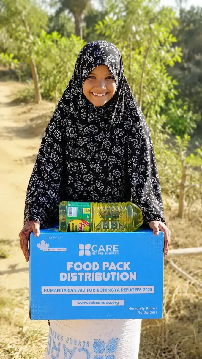 A woman receives a CBB food pack of staples and oil