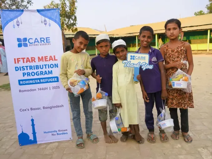 A boy holds a CBB food pack at a distribution