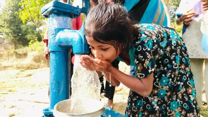 A family collects safe water from a CBB well