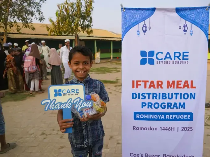 A boy receives a CBB iftar meal box