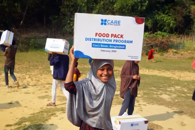 A woman with her CBB food pack at a distribution