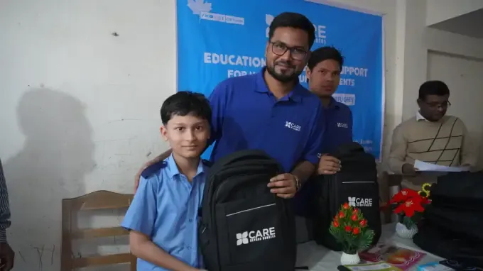 A boy with a CBB school backpack at a distribution