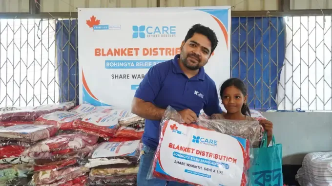 A CBB volunteer with children receiving blankets