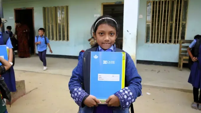 A girl holds a CBB school folder