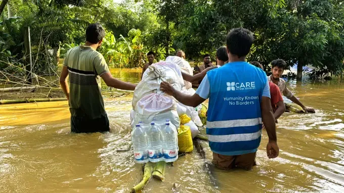 A CBB volunteer delivers relief to families in a flood