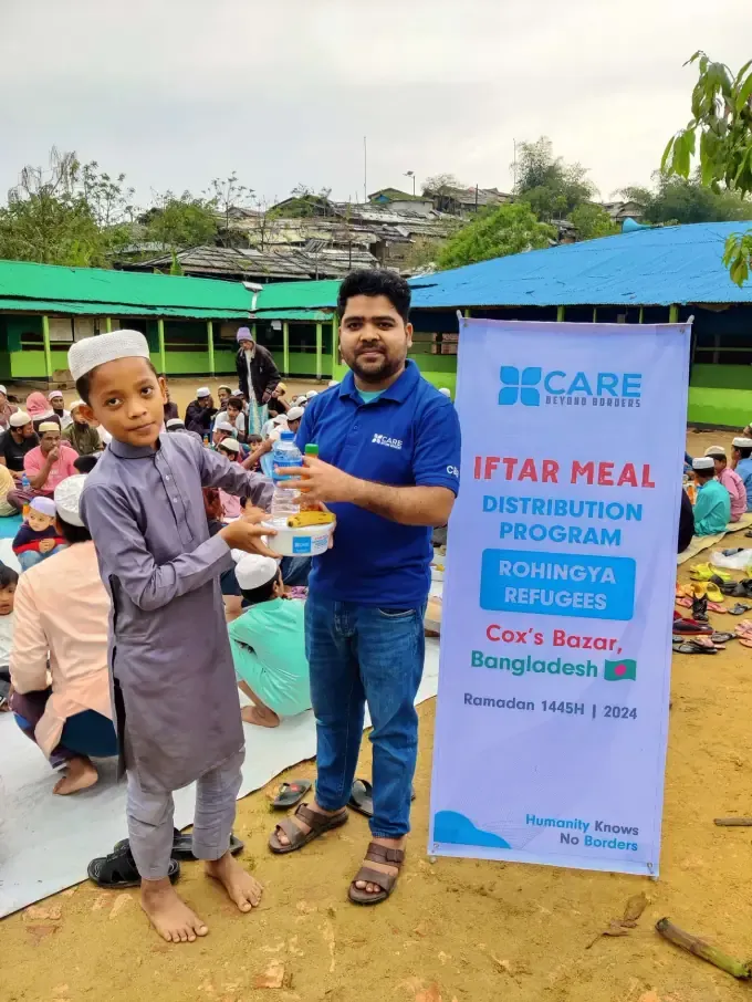 A CBB volunteer with children at a Ramadan distribution