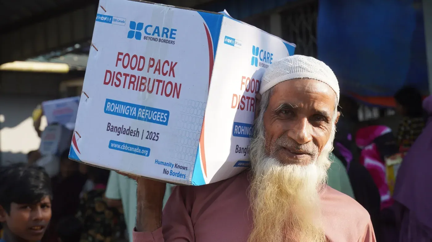 A man carrying a CBB Canada food pack at a distribution for Rohingya refugees in Bangladesh