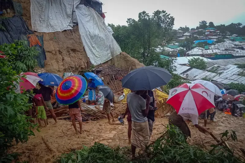 A flooded, muddy lane between shelters after a monsoon landslide in the camp